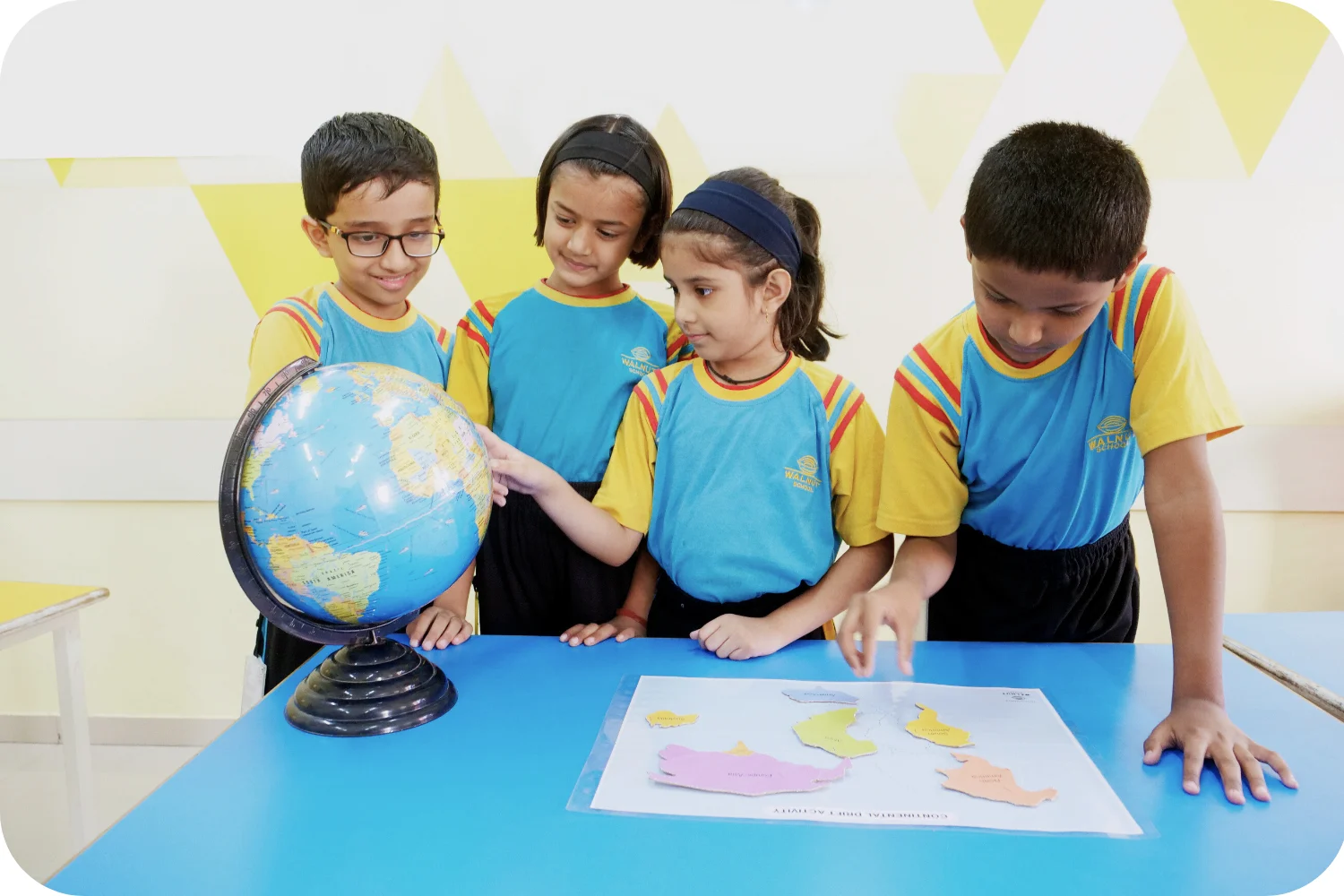 Walnut School students exploring geography with a globe and map activity
