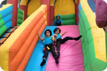 Walnut School kindergarten students enjoying the giant inflatable slide at the fun fair.
