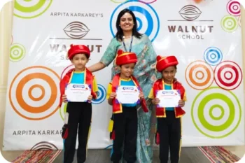 Walnut School kindergarten graduates receiving certificates with their teacher on Graduation Day.